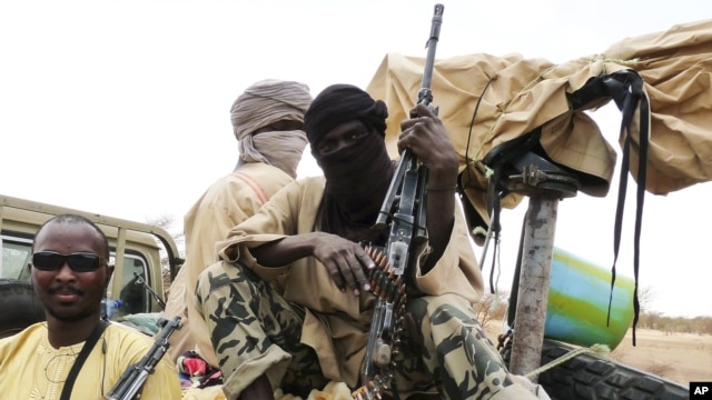 Militiamen from the Ansar Dine Islamic group sit on a vehicle in Gao in northeastern Mali, June 18, 2012. 