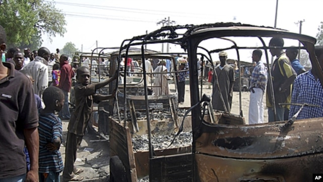 Residents survey vehicles damaged after a bomb blast at a primary school in Maiduguri, the capital of Nigeria's Borno state, February 29, 2012. 