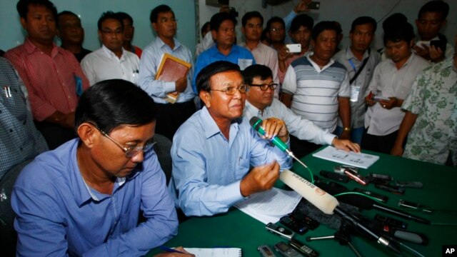 Opposition National Rescue Party's Vice President Kem Sokha, center, gives a press conference at his party's office in Phnom Penh, Cambodia, Aug. 12, 2013. 