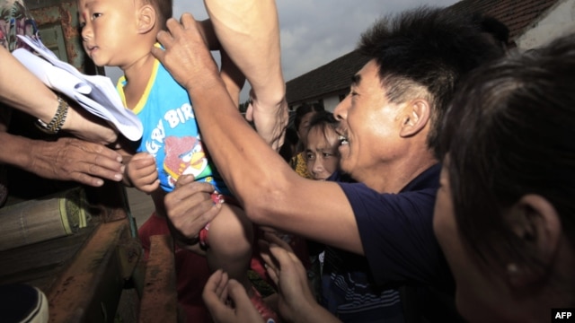 Chinese families evacuate their homes in the outskirts of Shanghai on August 7, 2012, ahead of Typhoon Haikui.