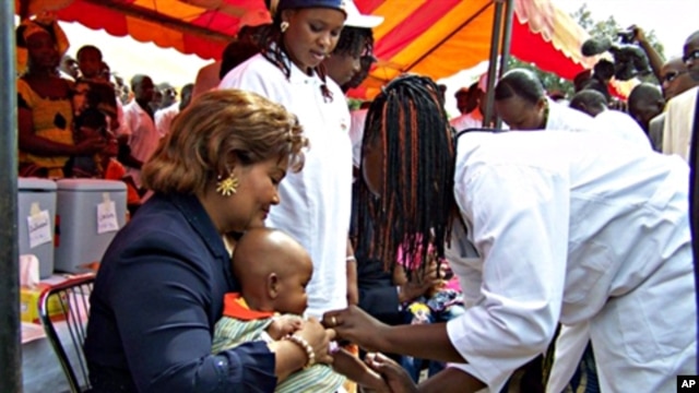 Newly re-elected president Blaise Compaore's wife Chantal holds a young boy during the launch of a new vaccination campaign against meningitis in Ouagadougou, Burkina Faso, 06 Dec. 2010