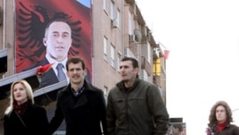 Građani Kosova prolaze pored velikog postera sa likom bivšeg komandanta OVK-a i bivšeg premijera Kosova Ramuš Haradinaj