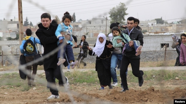 Warga Suriah melarikan diri dari kota Ras al-Ain ke kota perbatasan Suriah-Turki, di wilayah Ceylanpinar, propinsi Sanliurfa (9/11). Pesawat jet tempur Suriah menggempur wilayah ini, Senin (12/11).