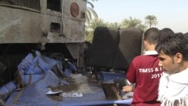 Relatives of victims look at the wreckage of a bus after a train crashed into it in Assuit province, some 300 kilometers south of Cairo, November 17, 2012.