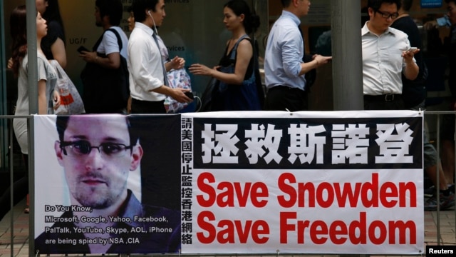 Người dân đi qua một tấm biểu ngữ ủng hộ anh Snowden, một cựu nhân viên hợp đồng làm việc tại NSA, Quận Trung tâm tài chính Hồng Kông, 18/6/2013.