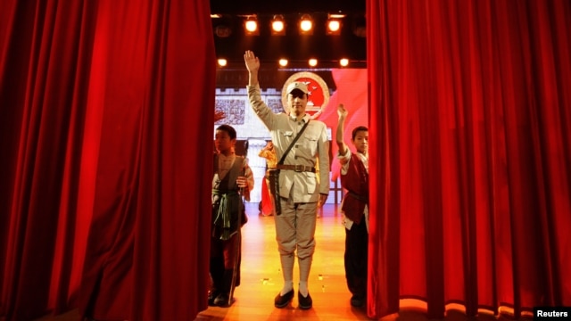 An actor dressed as an Eighth Route Army soldier waves after a performance at the Eighth Route Army Culture Park, one of two theme parks, in Wuxiang county, north China's Shanxi province, October 20, 2012. 