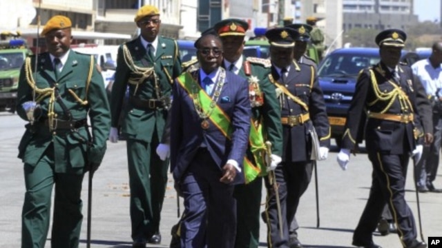Zimbabwe's President Robert Mugabe, (C) surrounded by military officers, leaves after opening the 4th Session of the 7th Parliament in Harare September 6, 2011. 