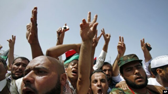 People flash victory signs as they gather at Martyrs Square after Friday prayers in Tripoli, September 2, 2011