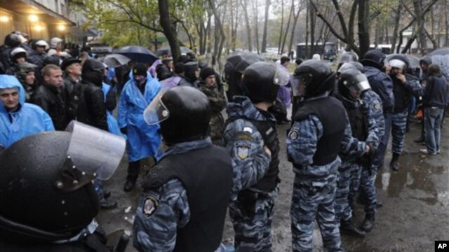 Riot police separate opposition and pro-government activists outside an election precinct in Kiev where the opposition alleged election fraud in Kiev, Ukraine, November 2, 2012.