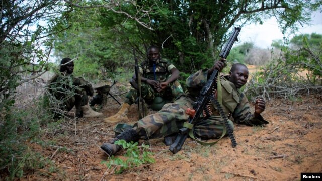 A soldier serving with the African Union Mission in Somalia takes up a defensive position in a fire fight during their joint AMISOM and Somali National Army (SNA) operation to seize and liberate territory from al-Shabab militants in Deyniile, Somalia, May