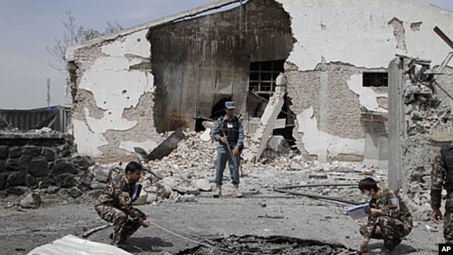 Afghan investigation team members assess the damage caused at the scene of a militant attack in Kabul, Afghanistan, May 2, 2012.