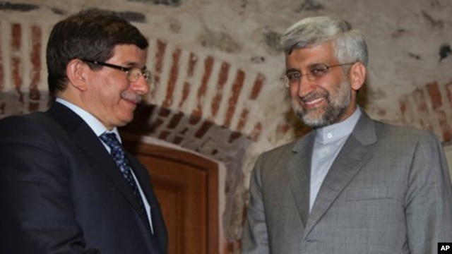 Turkey's Foreign Minister Ahmet Davutoglu (L) and Iran's Chief Nuclear Negotiator Saeed Jalili pose for cameras before their meeting on Iran's nuclear program, in Istanbul, Turkey, April 13, 2012. 