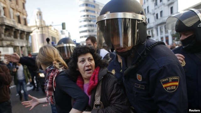 Protesters are pushed away by Spanish police officers during a 24-hour nationwide general strike in central Madrid November 14, 2012.