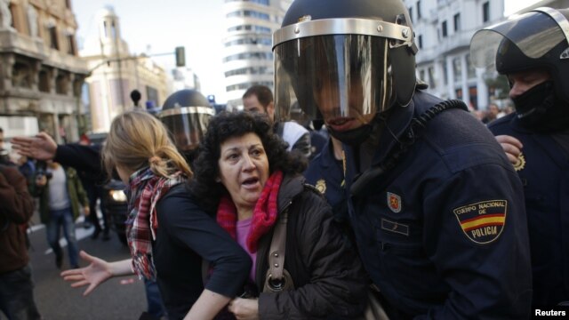 Polisi Spanyol mendorong para demonstran dalam aksi mogok di Madrid, Rabu (14/11).