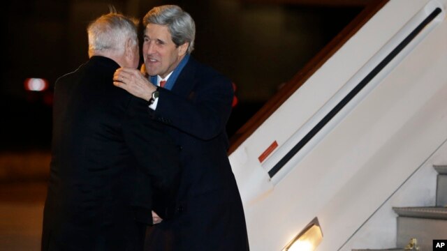 U.S. Secretary of State John Kerry, right, is greeted by U.S. Ambassador Louis Susman upon his arrival in Britain marking the start of his first official trip overseas, at Stansted Airport east of London, Feb. 24, 2013.