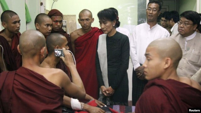 Burmese pro-democracy leader Aung San Suu Kyi visits Buddhist monks, wounded in a recent police crackdown on protesters against a copper mine project, November 29, 2012.