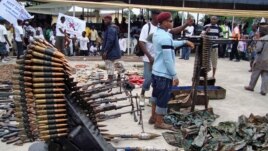An October 2009 photo shows Nigerian militant youths displaying weapons surrendered by former militants at an arms collection center in the oil hub Port Harcourt.