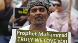 A Muslim protester holds up a sign during a protest against an anti-Islam film made in the U.S. mocking the Prophet Mohammad, outside the U.S embassy in Jakarta, September 21, 2012. 