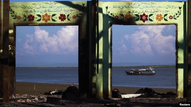 A boat is framed by the ruins of a destroyed mosque in a part of Pauktaw township that was burned in recent violence in Rakhine state, Burma, October 27, 2012.