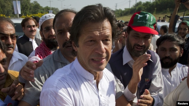 Imran Khan, cricketer-turned-politician and head of Pakistan Tehreek-e-Insaf (PTI) is surrounded with supporters as he leaves to lead a peace march against U.S. drone strikes from Islamabad to South Waziristan, October 6, 2012. 
