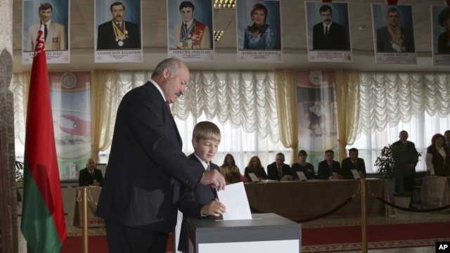 Belarusian President Alexander Lukashenko with his youngest son Nikolai casts his ballot at a polling station during parliamentary elections in Minsk, Belarus, Sunday, Sept. 23, 2012.