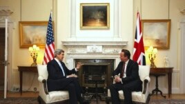 El primer ministro británico David Cameron, derecha, da la bienvenida al secretario de Estado de EE.UU., John Kerry, el lunes 25 de febrero en Londres. 