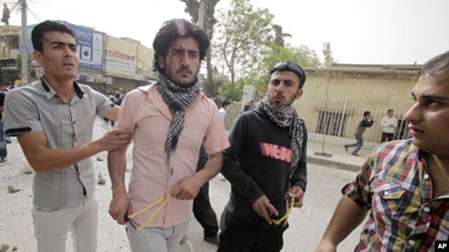 Protesters hold slingshots during clashes with riot policemen in Sulaimaniya, 260 km (162 miles) northeast of Baghdad, April 18, 2011