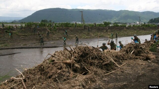 Japan's Self-Defense Force soldiers search for missing people at an area devastated by heavy rains at Ichinomiya-machi town in Aso, Kumamoto prefecture,July 15, 2012.   