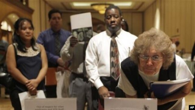 Vera Roybal, right, of Las Vegas, reads flyers at a temporary employment agency table during a job fair in Las Vegas, where unemployment rate is 14.7 percent,  05 Oct 2010