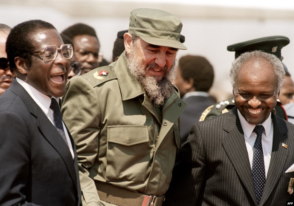 FILE - Cuban President Fidel Castro (C) is, flanked by Zimbabwean President Robert Mugabe (L), as he arrives in Harare, for the 8th non-aligned summit in Zimbabwe, Aug. 31, 1986.