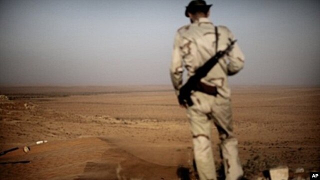 A Libyan rebel monitors Kadhafi loyalist forces as a sand storm sweeps the desert outpost of Twama, 30 km south-east of the western stronghold Zintan, on July 15, 2011. The lone outpost is the last defensive position of the rebels in the south of the Nafu
