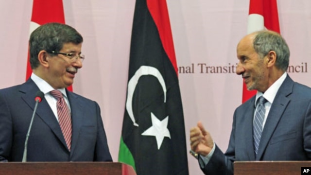 Turkish Foreign Minister Ahmet Davutoglu (L) attends a news conference with Mustafa Abdel Jalil, head of the rebel National Transitional Council, in Benghazi, August 23, 2011