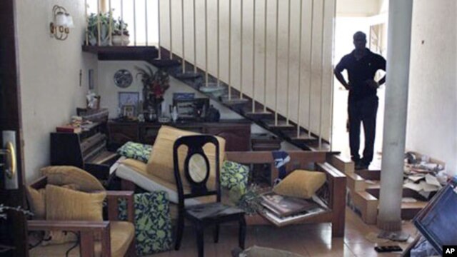 A relative stands in the looted home of Francois Konan Bany. Witnesses say dozens of armed militant youth loyal to Laurent Gbgabo tied up security guards, ransacked the home, and carried away everything of value, including kitchen appliances and air-condi