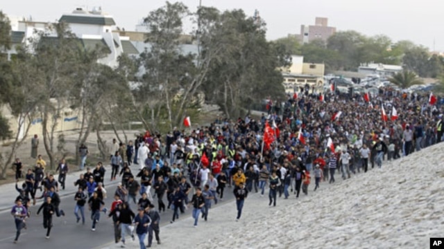 Anti-government protesters run toward Farooq Junction, also known as Pearl Square, after breaking barriers set up by police during a protest in Budaiya, west of Manama, Bahrain, February 13, 2012.