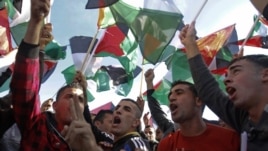 People wave Palestinians flags during celebrations for their successful bid to win U.N. statehood recognition in the West Bank city of Ramallah, Dec. 2, 2012.