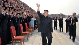 Lãnh đạo Bắc Triều Tiên Kim Jong-Un vẫy chào khi ông đến chụp ảnh với các giới chức, nghệ sĩ, và nhân viên của 1 studio ở Bình Nhưỡng, 19/4/2012