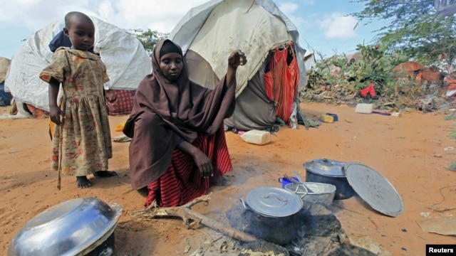 Kadija Mohamed cooks food for her children in a camp set up for internally displaced people in Dinsoor, in southern Somalia, January 5, 2012.