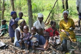 Women farmers take a break with their children in the village where they are part of a pioneering project to help control food production, as well as its distribution, and the use of the profits from their labor, in Naminya, Uganda, December 2011.
