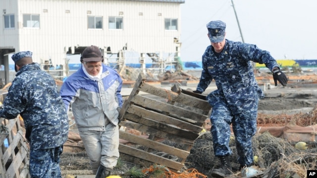 US sailors help remove debris during a cleanup effort at Japan's Misawa Fishing Port on March 14, 2011.