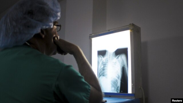 A doctor from an international cardiac mission examines the x-ray of a patient's heart in the Degand Clinic in Port-au-Prince, Haiti, April 15, 2012. 