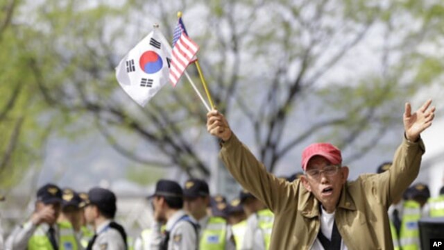 Anti-North Korea protester shouts as he holds the US and South Korean flags during a rally denouncing the North's recent announcement in Seoul, South Korea, April 24, 2012.