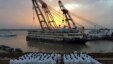 FILE - Rescue workers stand on the river bank as the capsized cruise ship Eastern Star is pulled out of the Yangtze against sunset, in Jianli, Hubei province, China, June 5, 2015.