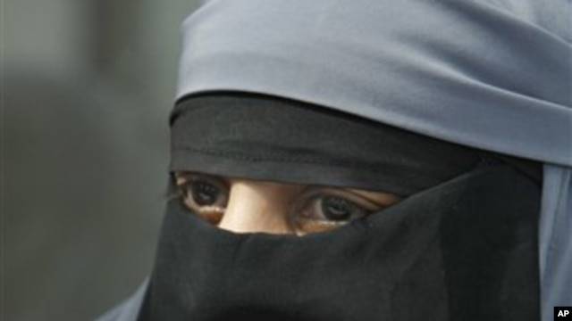 A woman dressed in a niqab, speaks with reporters during a press conference in Montreuil, east of Paris, 18 May 2010