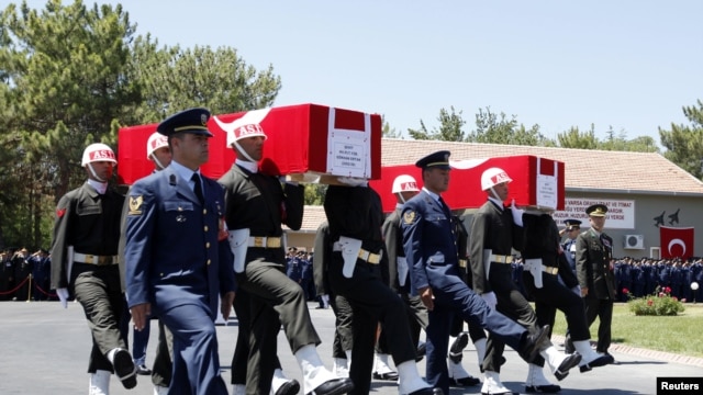 Turkish soldiers carry the coffins of fallen Turkish pilots, Captain Gokhan Ertan and Lieutenant Hasan Huseyin Aksoy, during an official farewell ceremony at the 7th Jet Main Air Base in the eastern Turkish city of Malatya July 6, 2012.
