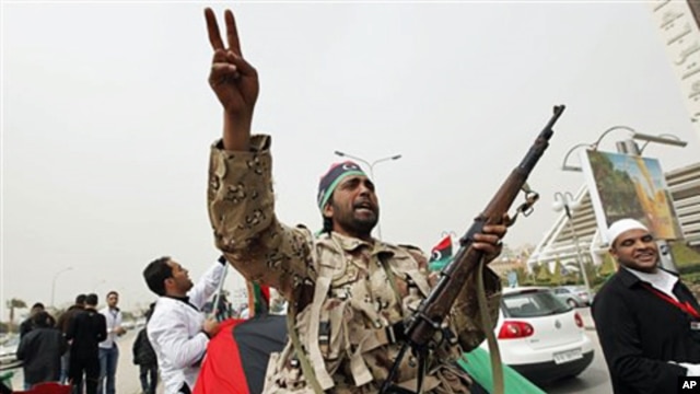 An armed Libyan rebel chant anti- Gadhafi slogans during a demonstration for students of the faculty of medicine of the University of Qar Younis, Benghazi, March 13, 2011