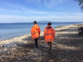 Volunteers from Swiss Cross, an aid organization for refugees in Greece, scan the sea, waiting to help new arrivals in Lesbos, April 1, 2016. (H. Murdock/VOA)