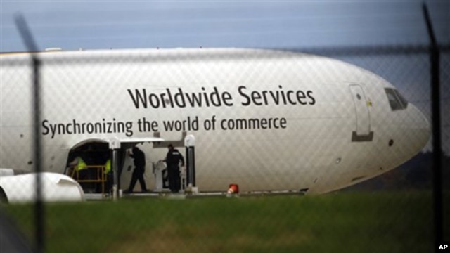 Investigators are seen with a United Parcel Service jet near the company's facility at Philadelphia International Airport, Friday, Oct. 29, 2010.