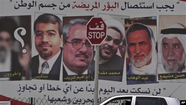 A car passes a pro-government billboard in Muharraq, Bahrain, with pictures of jailed Bahraini Shiite and Sunni opposition leaders, May 8, 2011