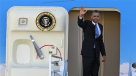 President Barack Obama waves as he boards Air Force One before departing the Orlando International Airport for Washington to monitor Hurricane Sandy, in Orlando, Florida, October 29, 2012.
