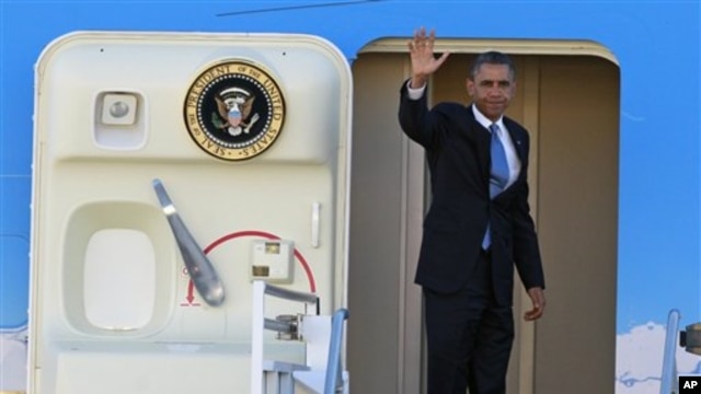 President Barack Obama waves as he boards Air Force One before departing the Orlando International Airport for Washington to monitor Hurricane Sandy, in Orlando, Florida, October 29, 2012.